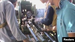 Para pemberontak Suriah mengoperasikan persenjataan yang berhasil mereka rampas dari tentara pemerintah (18/9). 