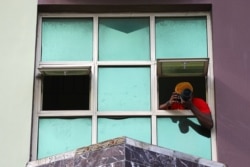 Adetona Omokanye, a 29 year-old documentary photographer, takes pictures from the window of his home in Lekki, Nigeria May 24, 2020. (REUTERS/Temilade Adelaja)