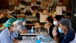 Migrant workers talk with the public health authorities for a COVID-19 investigation at a fresh market, amid the coronavirus disease (COVID-19) outbreak, in Bangkok, Thailand, December 22, 2020.