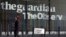 FILE - A woman walks past the offices of The Guardian newspaper in central London, August 20, 2013.