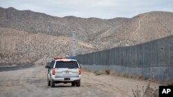 FILE - A U.S. Border Patrol agent drives near the U.S.-Mexico border fence in Sunland Park, N.M., Jan. 4, 2016.