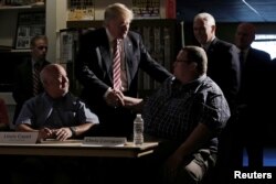 Republican nominee Donald Trump and his running mate Indiana Governor Mike Pence (back R) meet with local labor leaders and union members during a campaign stop in Brook Park, Ohio, Sept. 5, 2016.