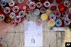 Candles, notes and paper cuttings lie next to the Love Monument in St. Julian, Malta, Oct. 17, 2017 the day after the killing of journalist Daphne Caruana Galizia.