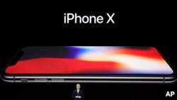 FILE - Apple CEO Tim Cook announces the new iPhone X at the Steve Jobs Theater in Cupertino, California, Sept. 12, 2017.