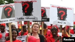 Para perempuan membawa plakat dalam protes menuntut pembebasan para siswi asrama putri yang diculik, di desa terpencil Chibok, di Lagos, Nigeria.