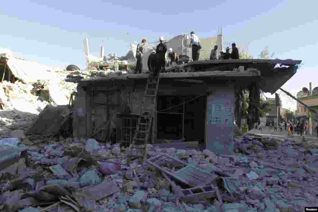 Residents look for survivors through rubble after what activists described as a barrel bomb attack by forces loyal to President Bashar Al-Assad in Aleppo, May 1, 2014.