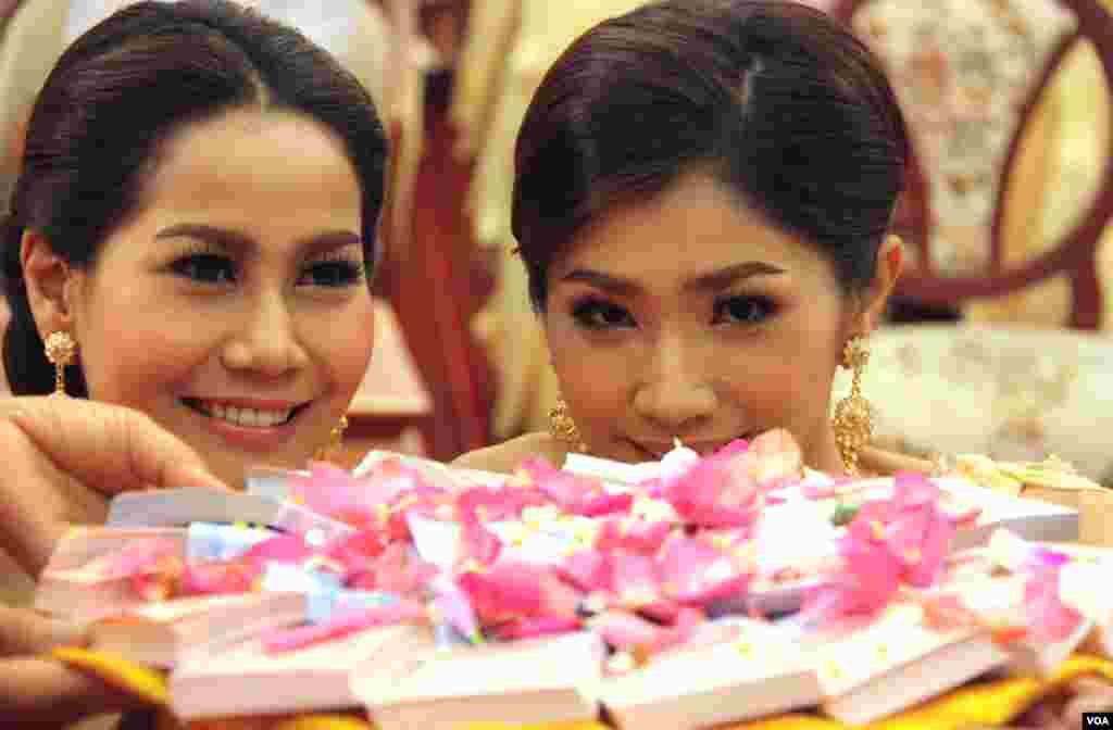 Pasangan pengantin melihat pinggan berisi hadiah uang atau angpau dalam upacara tradisional Thai. (VOA/Daniel Schearf)