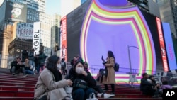 15일 미국 뉴욕 타임스퀘어에서 여행객들이 마스크를 착용하고 있다. 