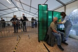 A person receives the Oxford/AstraZeneca coronavirus vaccine at an NHS vaccination center in York, England, Jan. 22, 2021.