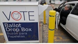 FILE - A voter drops off his election ballot in the drop box at the Cuyahoga County Board of Elections, in Cleveland, Ohio, April 22, 2020.