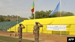 Casques bleus de la MINUSMA saluant les drapeaux du Mali et de l'Onu, le 29 mai 2015, Bamako, Mali.