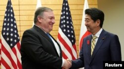 Menteri Luar Negeri Amerika Mike Pompeo (kiri) berjabat tangan dengan PM Jepang Shinzo Abe, di Tokyo, Jepang, 6 Oktober 2018.