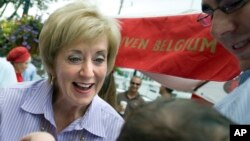 FILE - Linda McMahon talks with supporter David Becker and his baby daughter, Shelby, at a campaign stop in Fairfield, Conn., during her second bid for the U.S. Senate, Aug. 15, 2012. 