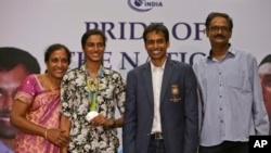 P.V. Sindhu, deuxième à gauche, qui a remporté une des deux médailles de l'Inde aux Jeux Olympiques de Rio de Janeiro pose avec son entraîneur Pullela Gopichand, deuxième à droite, la mère, P. Vijaya, à gauche, et le père, P.V. Ramana, à droite, au cours de leur réception au Gopichand Acade., Inde