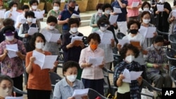 People wearing face masks to help protect against the spread of the coronavirus pray while maintaining social distancing during a service at the Chogyesa temple in Seoul, South Korea, Sunday, Aug. 23, 2020. (AP Photo/Ahn Young-joon)