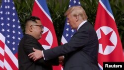 미북 정상회담에 앞서 지난 6월 도널드 트럼프 미국 대통령(오른쪽)과 김정은 위원장이 만나 인사를 나누고 있다.