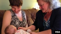 Certified Nurse Midwife Mairi Breen Rothman checks baby Debra as her mother, Beth Drake, looks on. September 25, 2014, VOA, J.Taboh