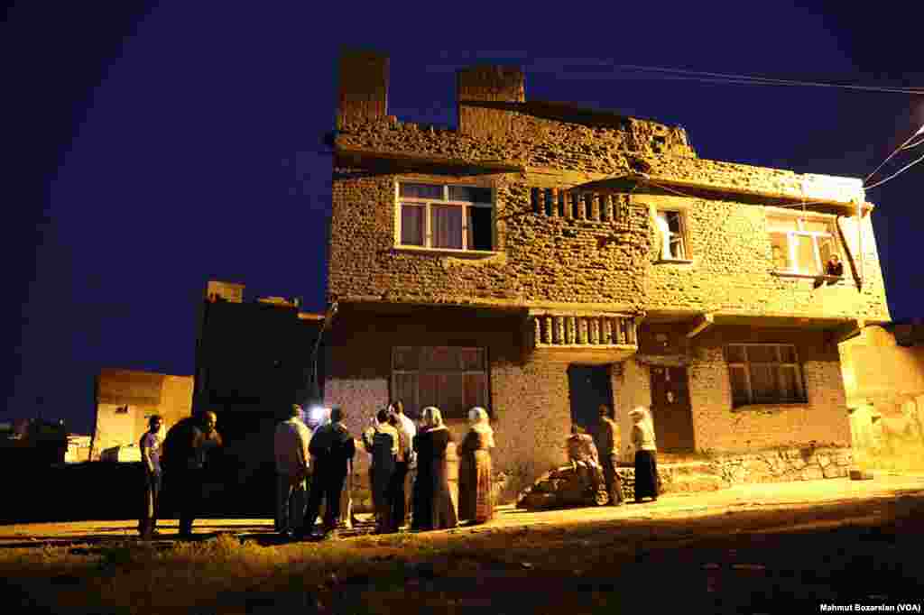 The government has cut power and water to Sur, in Diyarbakir, Turkey, as efforts are made to rebuild it. Residents who remain stand under street lamps at night to discuss their situation.