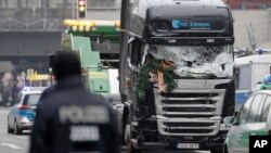 The damaged towing truck is towed away from the crime scene in Berlin, Germany, Tuesday, Dec. 20, 2016, the day after the truck ran into a crowded Christmas market.