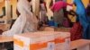 FILE - A handout photo released by the WFP shows women sitting next to WFP-distributed specialized food to combat malnutrition in children at the Pompomari camp in Damaturu on Jan. 26, 2017 during a visit by the WFP executive director.