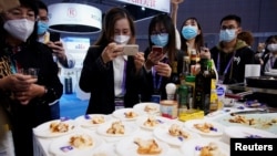 资料照片：在上海参观中国国际进口博览会上的观展者给澳大利亚龙虾拍照。（2020年11月6日）