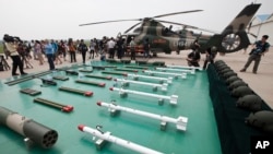 FILE PHOTO - Journalists film weapons for Chinese Army Z-9WZ attack helicopter, background, designed and manufactured by China, during a demonstration for the press at a base of Army Aviation 4th Helicopter Regiment, ahead of Army Day on Aug. 1.