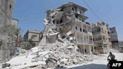 A Syrian man rides a motorcycle in the town of Ariha, in the south of Syria's Idlib province, Aug. 2, 2019. Air strikes stopped after the government agreed to a truce after weeks of bombardment of the rebel-held region, monitors said.