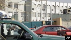 An Afghan policeman stands guard outside of Kabul police headquarters gate, where an American adviser was killed in Kabul, Afghanistan, December 24, 2012.