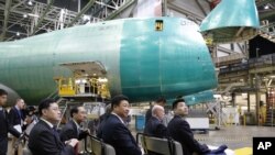 2015年9月23日，秦刚（前左一）随同中国国家主席习近平参观美国华盛顿州埃弗里特的波音工厂