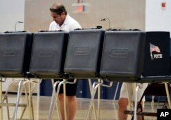 A voter looks over a ballot during New Mexico's primary elections at La Cueva High School in Albuquerque, N.M., June 5, 2018.