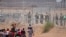 Migrants seeking to enter the United States through a barbed wire fence installed along the Rio Grande are driven away with pepper spray shots by Texas National Guard agents at the border with Ciudad Juarez, Chihuahua State, Mexico, on May 13, 2024. (Phot