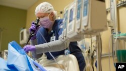 Organ procurement coordinator Lindsey Cook performs a bronchoscopy and removes mucus from the lungs of an organ donor at Mid-America Transplant Services in St. Louis. Nurses like Cook perform this procedure every 4 to 6 hours to keep the lungs clear as a body is kept viable while waiting to donate its organs. (AP Photo/Whitney Curtis)