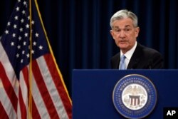 Federal Reserve Chair Jerome Powell gathers his notes as he concludes his news conference in Washington, March 20, 2019.