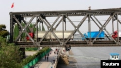Trucks wait for border inspection at the Chinese end of the Friendship Bridge that connects Sinuiju, North Korea, with Dandong, Liaoning province, China, over the Yalu River, May 24, 2018. China, North Korea's biggest trading partner, enforced sanctions strictly in the second half of 2017, hurting North Korea’s manufacturing sector.