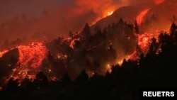 Lava pours out of a volcano in the Cumbre Vieja national park at El Paso, on the Canary Island of La Palma, September 19, 2021, in this screen grab taken from a video. 