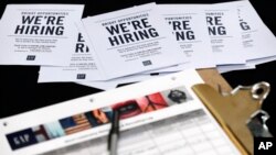 FILE - Job applications and information for the Gap Factory Store sit on a table during a job fair at Dolphin Mall in Miami, Oct. 6, 2015.