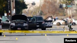 មន្រ្តី​ប៉ូលិស​ម្នាក់​រើស​កាំភ្លើង​ពី​កន្លែង​ស៊ើបអង្កេត​នៅ​ជុំវិញ​កន្លែង​ដែល​រថយន្ត​ស្ព័រ​ ទី​ដែល​ជន​សង្ស័យ​ពីរ​នាក់​ត្រូវ​បាន​បាញ់​សម្លាប់​ដោយ​ប៉ូលិស ​បន្ទាប់​ពី​មាន​ការ​បាញ់​សម្លាប់​រង្គាល​នៅ​ក្នុង​ក្រុង San Bernardino រដ្ឋ California កាលពី​ថ្ងៃទី៣ ខែធ្នូ ឆ្នាំ២០១៥។