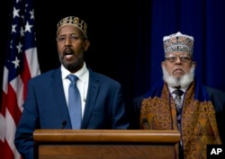 FILE - Abdisalam Adam a public school teacher and imam from St. Paul, Minn. (left) and Imam Sheikh Sa'ad Musse Roble, of the World Peace Organization in Minneapolis, participate in the White House Summit on Countering Violent Extremism, Feb. 18, 2015.