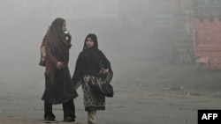 Pedestrians walk along a road engulfed in thick smog in Lahore, Pakistan, Nov. 11, 2024.