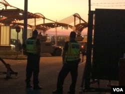 As night fell, Hungarian police watch tanks get in place ahead of the entrance of hundreds of travelers from the Middle East, Asia and Africa, Hungarian Border in Croatia, Sept 23, 2015. (VOA Photo By: H.Murdock).