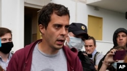 Roman Dobrokhotov, chief editor of The Insider walks surrounded police officers and journalists, in Moscow, Russia, July 28, 2021. 