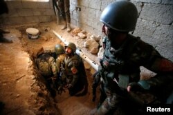 FILE - Peshmerga forces inspect a tunnel used by Islamic State militants in the town of Bashiqa, after it was recaptured from the Islamic State, east of Mosul, Iraq, Nov. 12, 2016.
