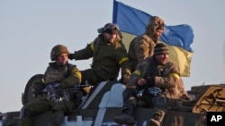 FILE - Ukrainian troops ride atop an armored vehicle outside Artemivsk, eastern Ukraine.