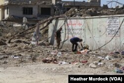 Hazzam Abdulghani, right, and his brother examine a body to see if it their 17-year-old nephew, Dhyab Idris Abdulghani, in Mosul, Iraq, June 15, 2017.