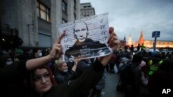 ស្ត្រីម្នាក់កាន់រូបប្រធានាធិបតីរុស្ស៊ីលោក Vladimir Putin ក្នុងការតវ៉ាប្រឆាំងរដ្ឋាភិបាលរុស្ស៊ី ពាក់ព័ន្ធនឹងការឃុំខ្លួនមេដឹកនាំបក្សប្រឆាំងលោក Alexie Navaly នៅទីក្រុងមូស្គូ រុស្ស៊ី កាលពីថ្ងៃទី ២១ ខែមេសា ឆ្នាំ ២០២១។