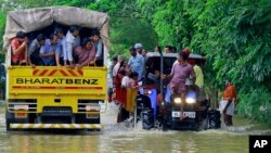 Des volontaires transportent des personnes sinistrée des inondations dans des tracteurs et camions à Kainakary, dans le district d'Alappuzha, dans l'État du Kerala, Inde, le 17 août 2018.