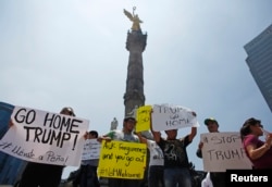 Demonstrators hold placards during a protest against the visit of U.S. Republican presidential candidate Donald Trump at the Angel of Independence monument in Mexico City, Mexico, Aug. 31, 2016.