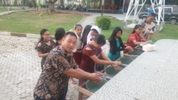 Umat yang melakukan cuci tangan sebelum mengikuti misa di Gereja Katolik Santa Maria Palu (22/3/) (Foto: VOA/Yoanes Litha).