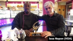Le lauréat André Bayala et le propriétaire de la boulangerie, à Ouagadougou, Burkina Faso, le 4 mars 2017. (VOA/Issa Napon)