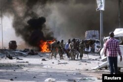 Somalian government forces evacuate their injured colleague, from the scene of an explosion in KM4 street in the Hodan district of Mogadishu, Oct. 14, 2017.